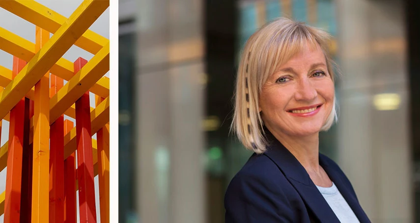 Porträt einer lächelnden Businessfrau vor moderner Architektur und Kunstobjekt